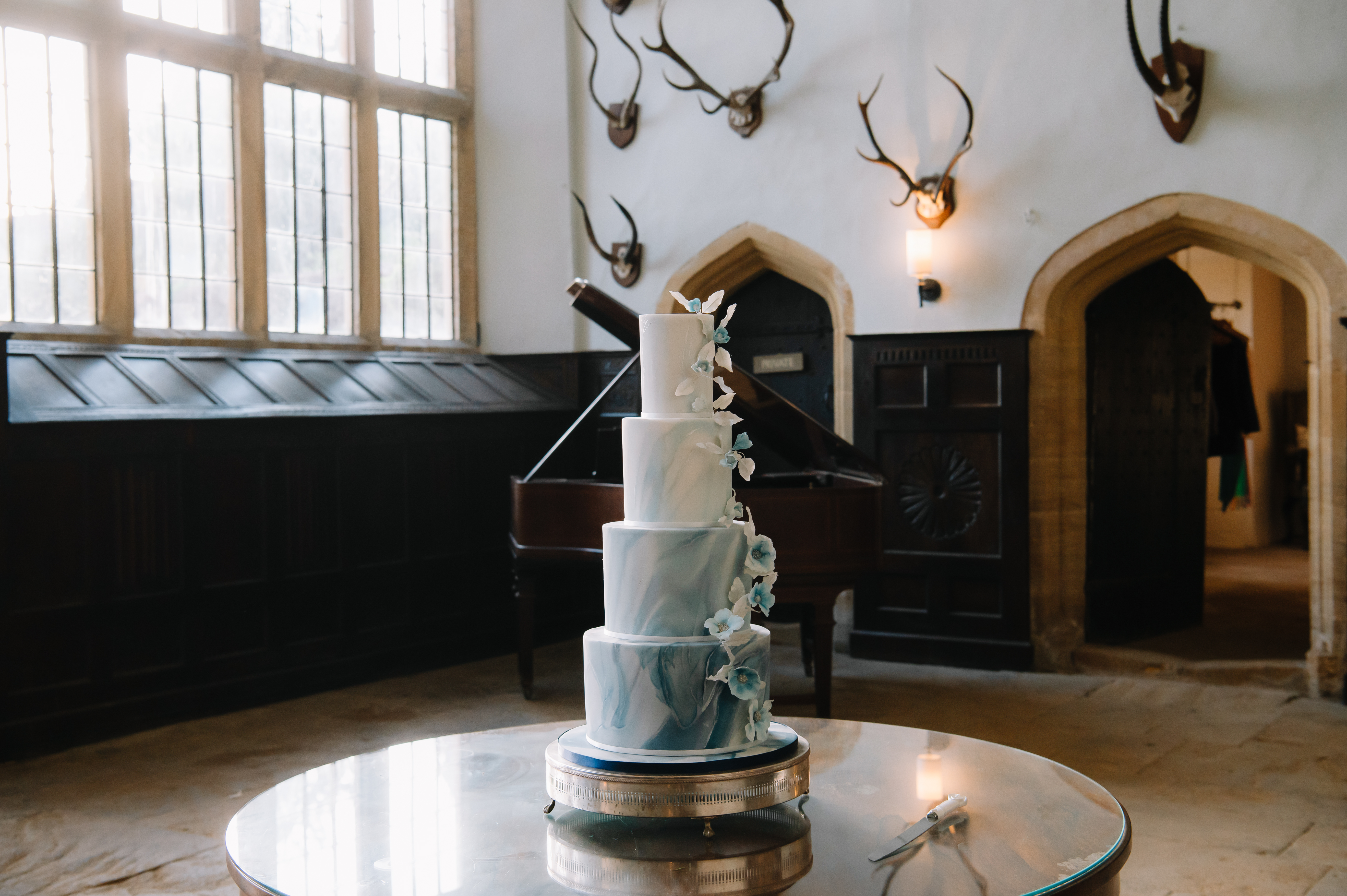 4 Tier Round Blue and White Ombre Marbled Wedding Cake with Cascading Blue and White Sugar Flowers and Foliage by Cocoa & Whey Cakes in Dorset