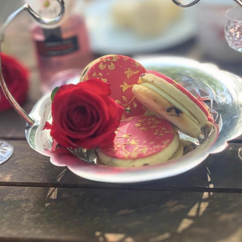 A small silver dish with a red rose and 3 pink and gold double chocolate filled butter cookies in Cherry & Rose by Cocoa & Whey Cakes